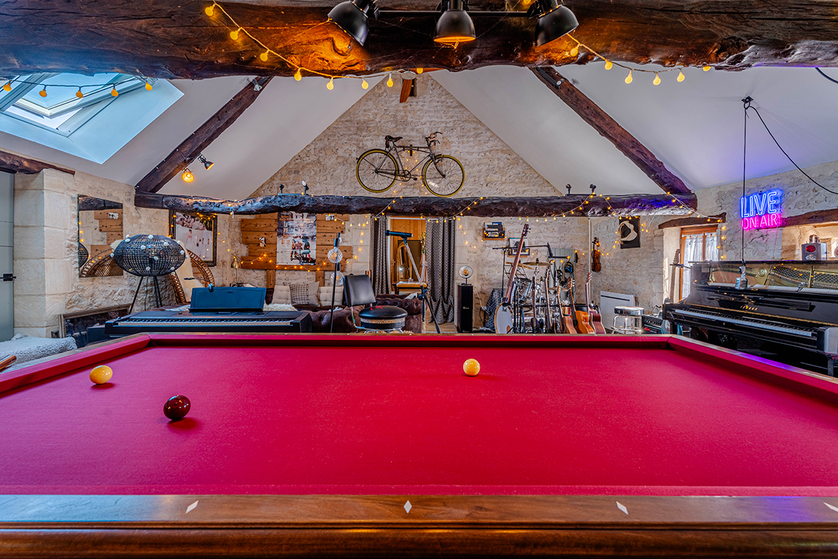 Grande salle de loisirs avec billard français et ambiance chaleureuse au gîte L’Écrin en Bessin