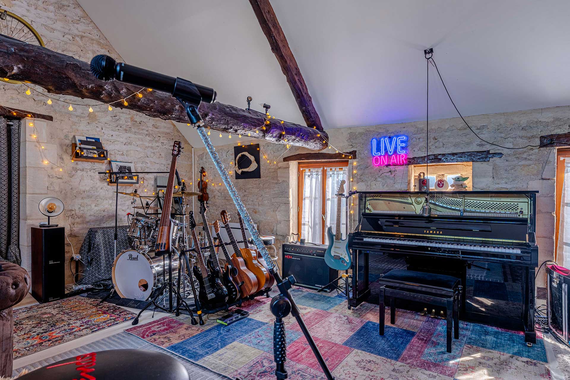 Salle de musique avec piano, guitares et batterie – gîte L’Écrin en Bessin